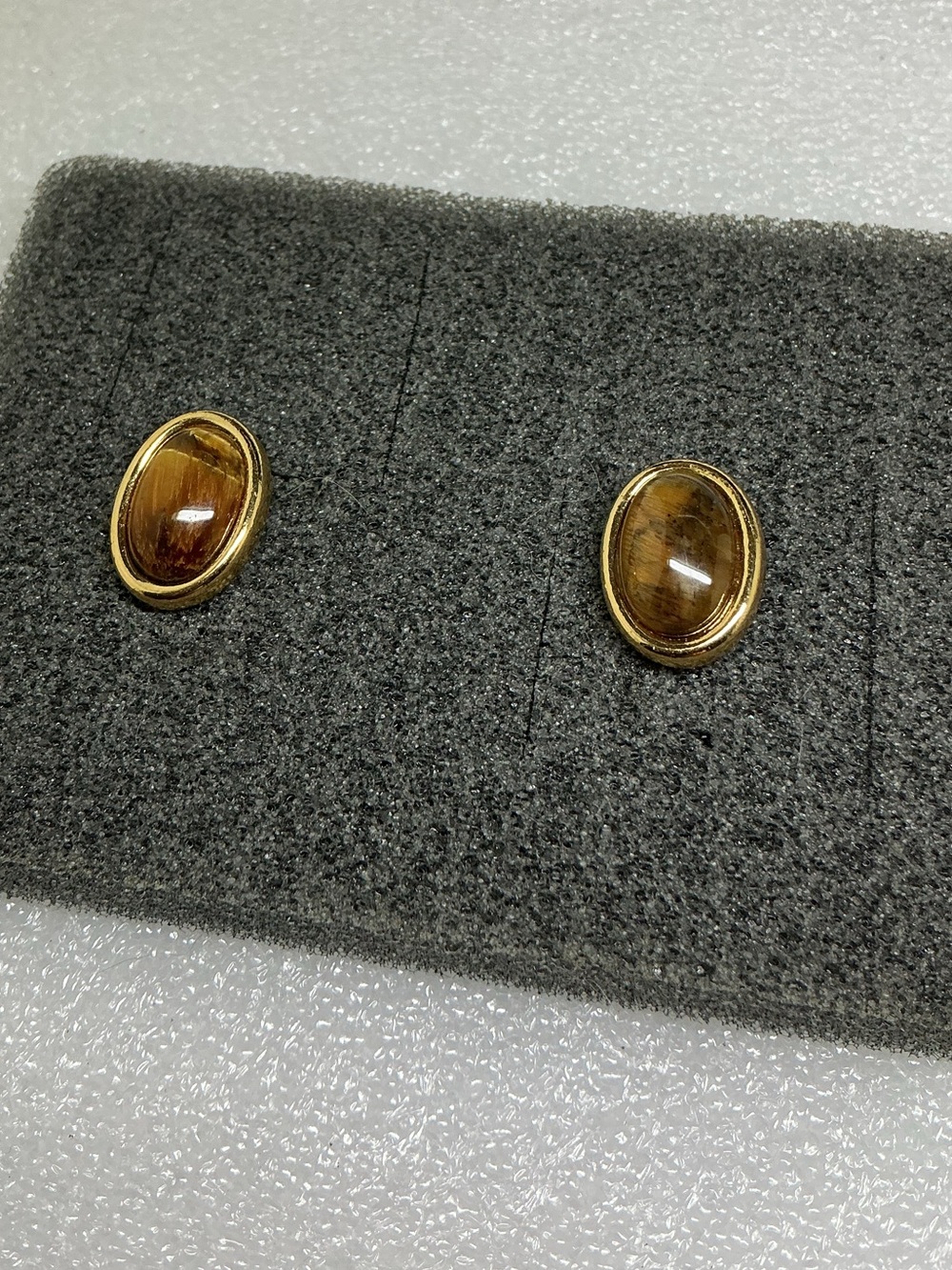 gold-tone stud earrings featuring polished oval Tiger’s Eye cabochons